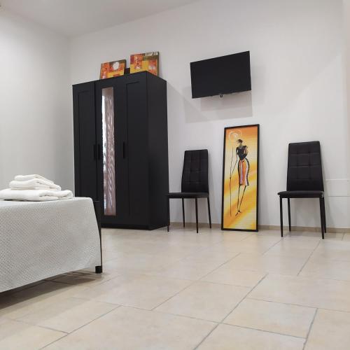 a room with two chairs and a painting on the wall at STRADONE 132 in Gravina in Puglia