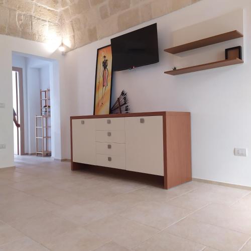 a living room with a tv on a wall at STRADONE 132 in Gravina in Puglia