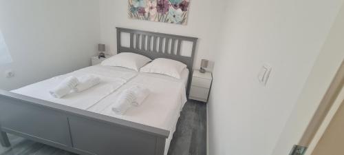 a bedroom with a white bed with white pillows at House Vallis Aurea in Povile