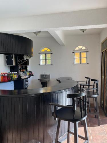 eine Bar in einem Restaurant mit schwarzen Stühlen in der Unterkunft Starlight Chalet & Health Spa in Spa Spring