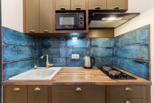 a kitchen with a sink and a stove and a microwave at DayFlat Apartments Maidan Area in Kyiv