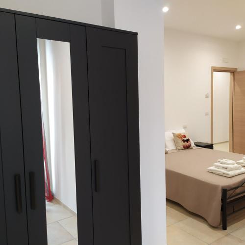 a bedroom with a bed and a black closet at STRADONE 132 in Gravina in Puglia