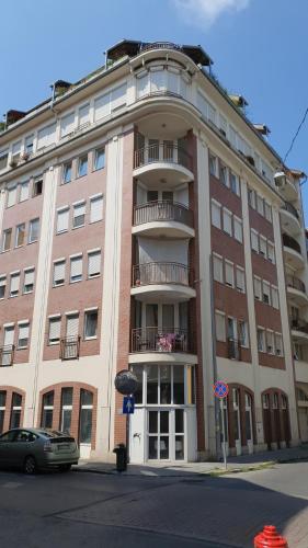 a large brick building with a balcony on a street at Modern top floor loft with balcony in Budapest