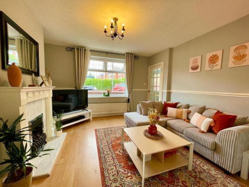 a living room with a couch and a fireplace at Cosy Croft Cottage in Greasbrough