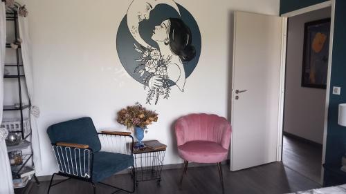 a living room with two chairs and a painting on the wall at Millésime in Perville