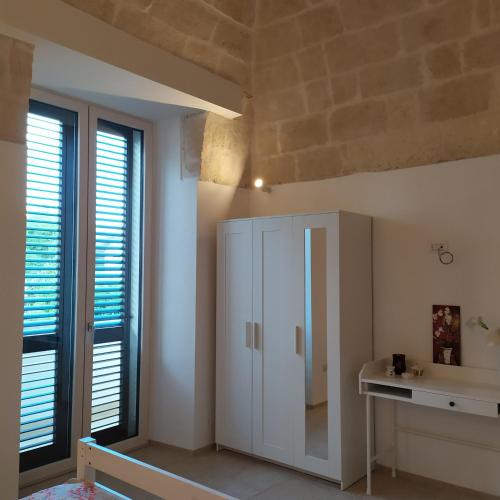 a room with a white cabinet and two windows at STRADONE 132 in Gravina in Puglia