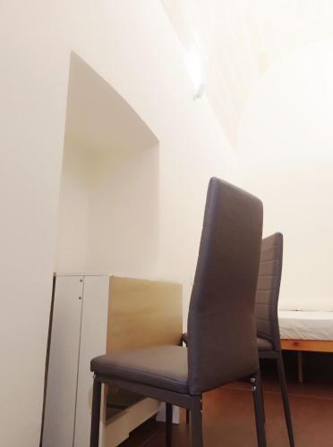 a black chair sitting in a room with a bed at STRADONE 132 in Gravina in Puglia