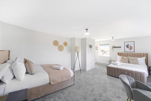 a bedroom with two beds and a chair at LiveStay - London Chiswick Apartments with Free Parking in London