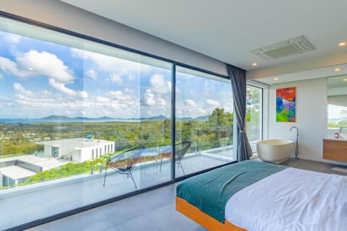 1 dormitorio con ventana grande con vistas en 普吉岛Yamu 海滩 豪华舒适 海景双泳池6卧室独栋別墅 -五星级含佣人 车位, en Por Bay