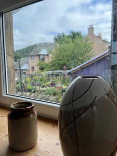 un vase assis sur une table devant une fenêtre dans l'établissement 2 smw, à Peebles