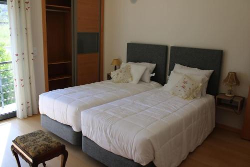 a bedroom with two beds with white sheets and pillows at Charming Religious House II in Fátima