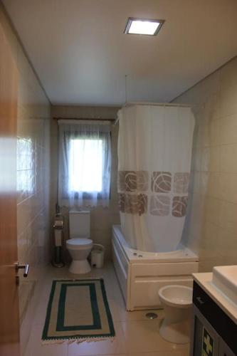 a bathroom with a tub and a toilet and a shower at Charming Religious House II in Fátima