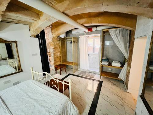 a bedroom with a bed and a large window at Charming Townhouse Prime Area Valletta in Valletta