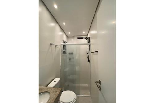 a bathroom with a shower and a toilet at Apartamento Boqueirao Proximo a Praia, com Piscina in Praia Grande
