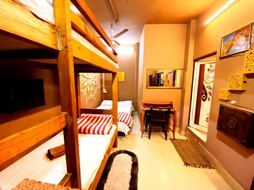 a small room with a bunk bed and a desk at Stay Inn Heritage in Varanasi
