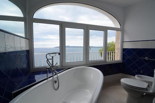 uma casa de banho com uma banheira, um WC e janelas em Villa Narcol em L'Estartit