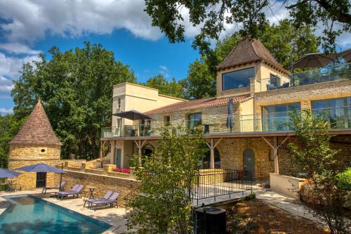 an exterior view of a house with a swimming pool at La Perle de Domme in Sarlat-la-Canéda