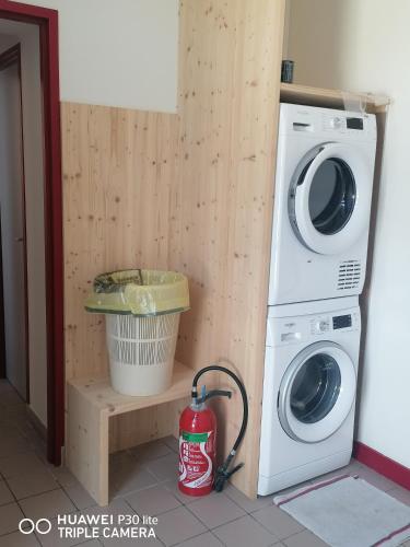 eine Waschmaschine und einen Trockner in einem Zimmer mit einem Eimer in der Unterkunft Gite d'Etape de Chirac in Chirac