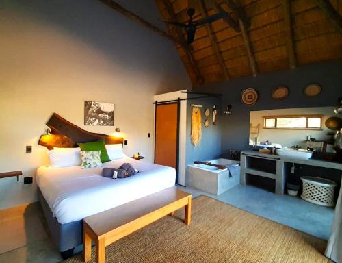 een slaapkamer met een bed en een badkamer met een wastafel bij Braai Safaris Lodge in Hoedspruit