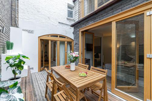 a patio with a wooden table and chairs on a deck at Stay Covent Garden in London
