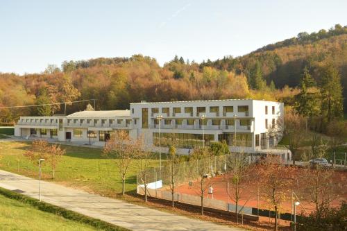 een groot wit gebouw voor een berg bij GO! Sport hotel & resort in Rogaška Slatina