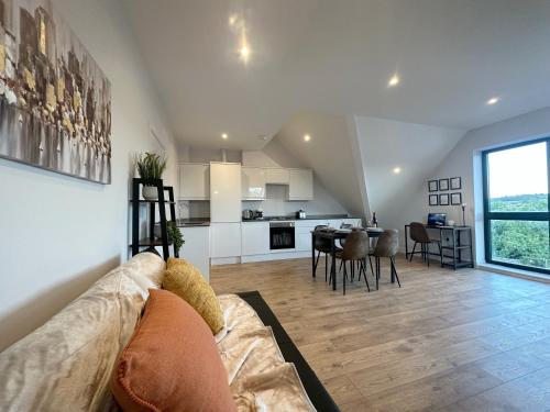 een woonkamer en een keuken met een bank en een tafel bij Stylish & Spacious Apartment in Royal Tunbridge Wells