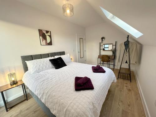 a bedroom with a large bed with two towels on it at Stylish & Spacious Apartment in Royal Tunbridge Wells