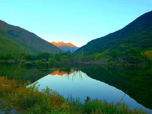 a view of a lake with mountains in the background at COZY house მყუდრო სახლი in Stepantsminda