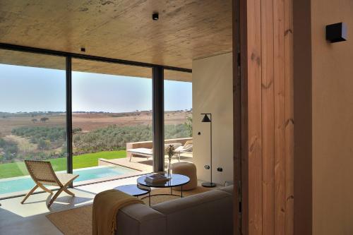 a living room with a couch and a table at Herdade da Malhadinha Nova - Relais & Châteaux in Albernoa