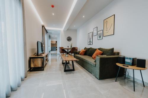 een woonkamer met een bank en een tafel bij Pearl Apartel in Volos