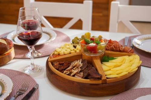 a table with a tray of food and a glass of wine at House Family Podhum in Dražice