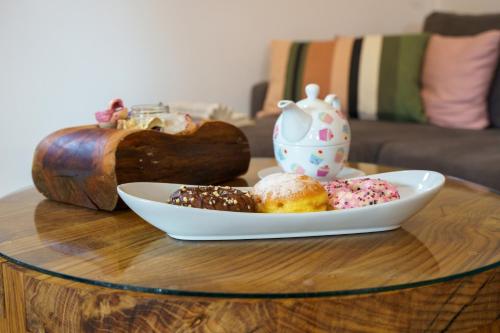 a table with a plate of donuts and a tea pot at House Family Podhum in Dražice