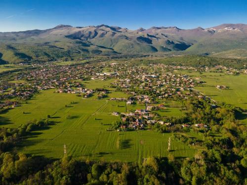 an aerial view of a village in a field with mountains at House Family Podhum in Dražice