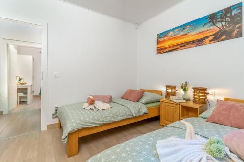 a bedroom with two beds and a dog laying on the bed at House Family Podhum in Dražice