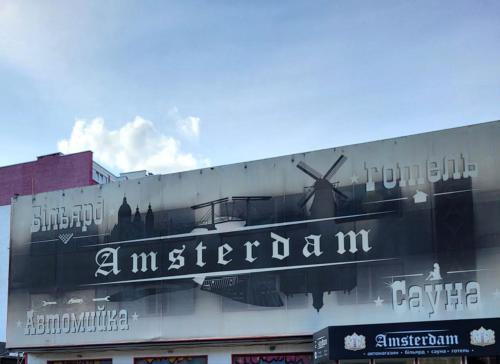 a sign on the side of a building with a windmill at Амстердам in Khmelʼnytsʼkyy
