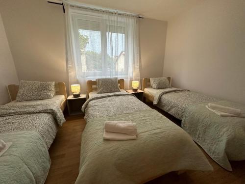 3 camas en una habitación con ventana en Mirabella House en Rzeszów