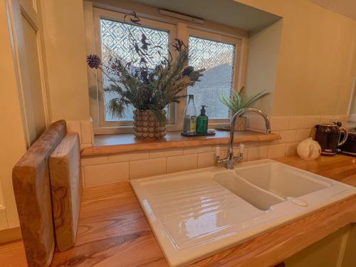 a kitchen with a sink and a window at Sunny Dene Cottage in Knapton