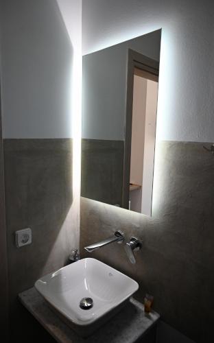 a white sink in a bathroom with a mirror at Costa Varda Apartments in Mourteri