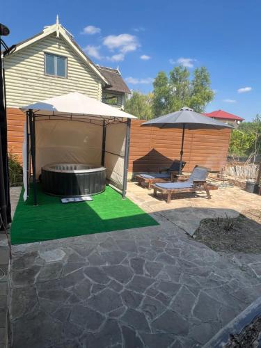 a backyard with a fire pit and an umbrella at Рыбацкий домик in Mayaki