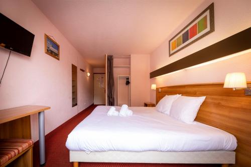 ein Schlafzimmer mit einem großen weißen Bett in einem Zimmer in der Unterkunft HOTEL DES NEIGES in Les Deux Alpes
