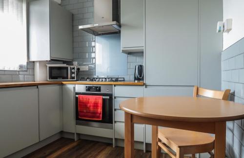 a small kitchen with a wooden table and a table and a table at Comfortable Room-Only Room in London