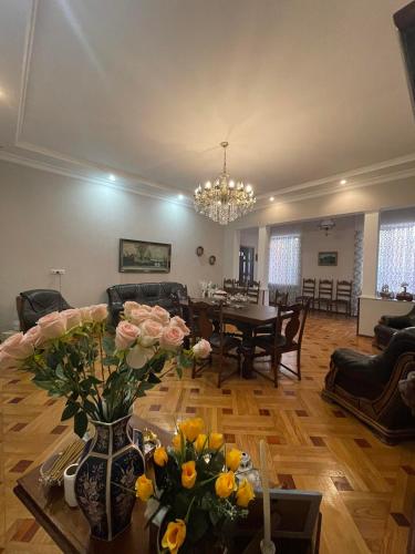 a living room with a couch and a table with flowers at Eliz Garden in Kutaisi