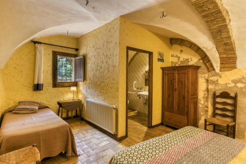 a bedroom with two beds and a sink in a room at Mas Alba in San Esteban de Guialbes