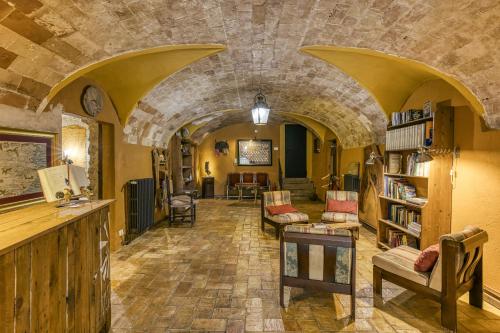 a living room with a stone wall and a library at Mas Alba in San Esteban de Guialbes