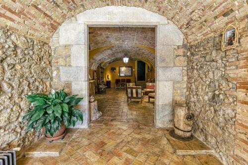 a stone hallway with a stone wall and a plant at Mas Alba in San Esteban de Guialbes