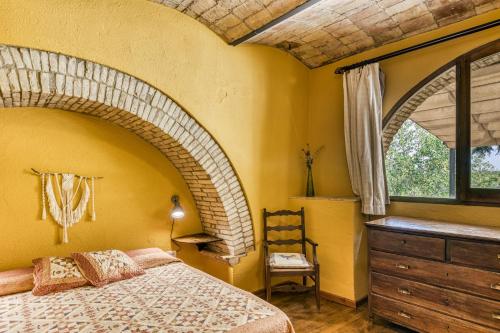 a bedroom with a large bed and a window at Mas Alba in San Esteban de Guialbes