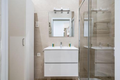 a white bathroom with a sink and a mirror at Apartamento acogedor y cómodo GUAD-C in Madrid