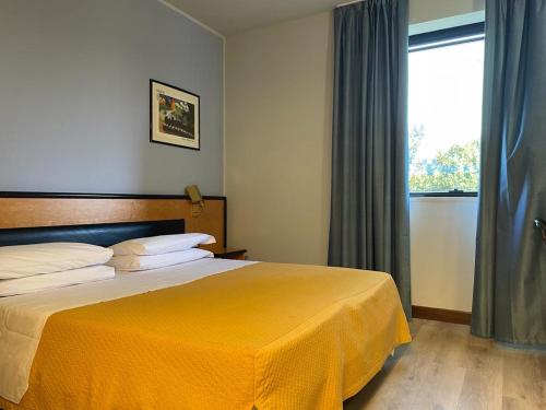 een slaapkamer met een groot bed en een gele deken bij Art & Hotel Treviolo in Treviolo