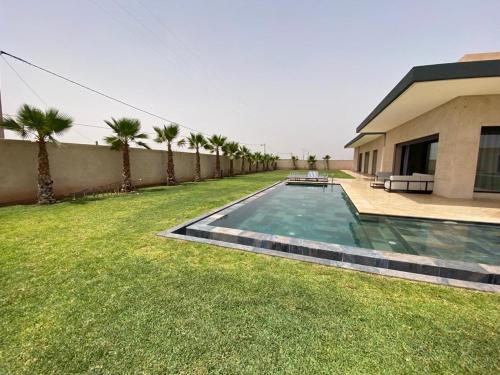 a swimming pool in a yard next to a building at Villa Nisrine Your Private Oasis With Pool and No Overlooking in Marrakech