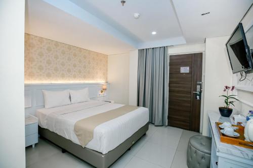 a hotel room with a bed and a television at The Cube Hotel Malioboro, Azana Hotels Collection in Yogyakarta